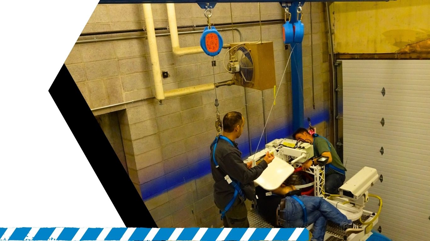 Height safety technicians inspecting anchor points while secured in full-body harnesses