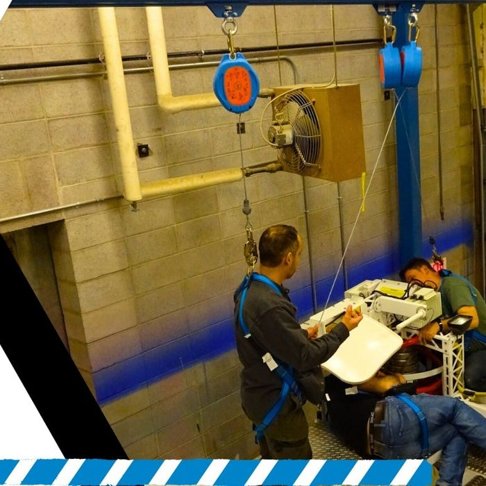 Height safety technicians inspecting anchor points while secured in full-body harnesses