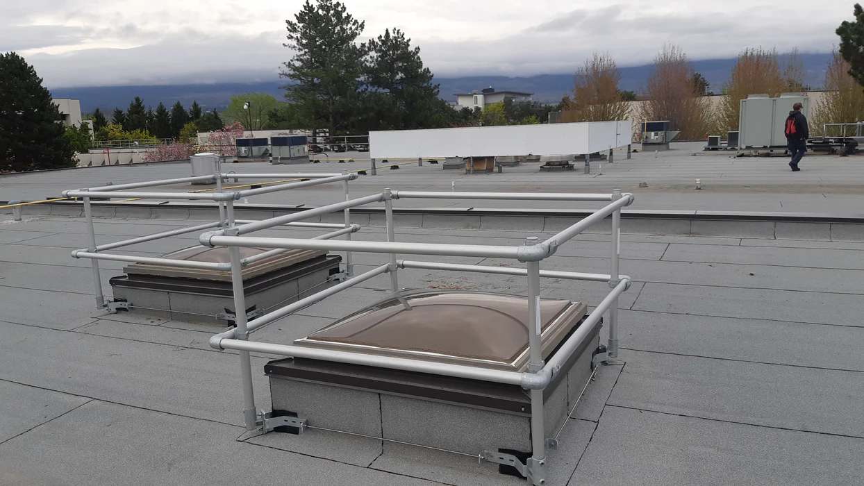 Rooftop metal railing is installed for height safety guards.