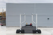 A ladder stabilizer is installed on the rooftop for fall safety.