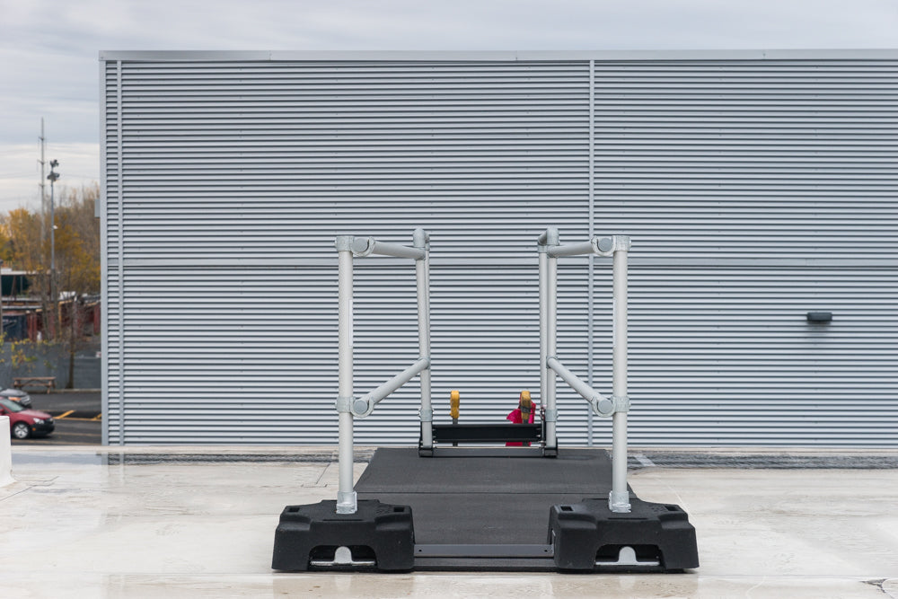 A ladder stabilizer is installed on the rooftop for fall safety.