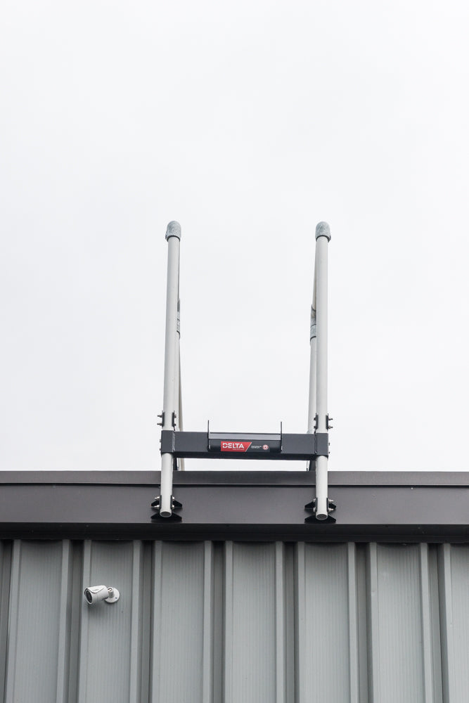 A ladder stabilizer is installed on the rooftop for fall protection