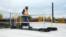 A ladder stabilizer is installed on the rooftop for height safety.