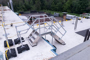 Metal staircase on a rooftop with safety barriers for fall protection
