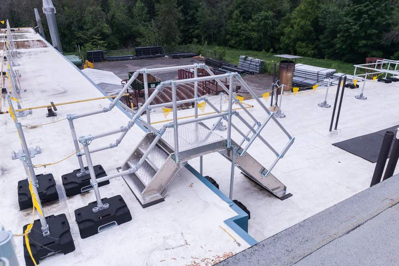 Metal staircase on a rooftop with safety barriers for fall protection