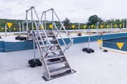 Metal staircase on a rooftop with safety barriers and flags