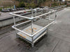 A metal platform with a safety railing on a rooftop